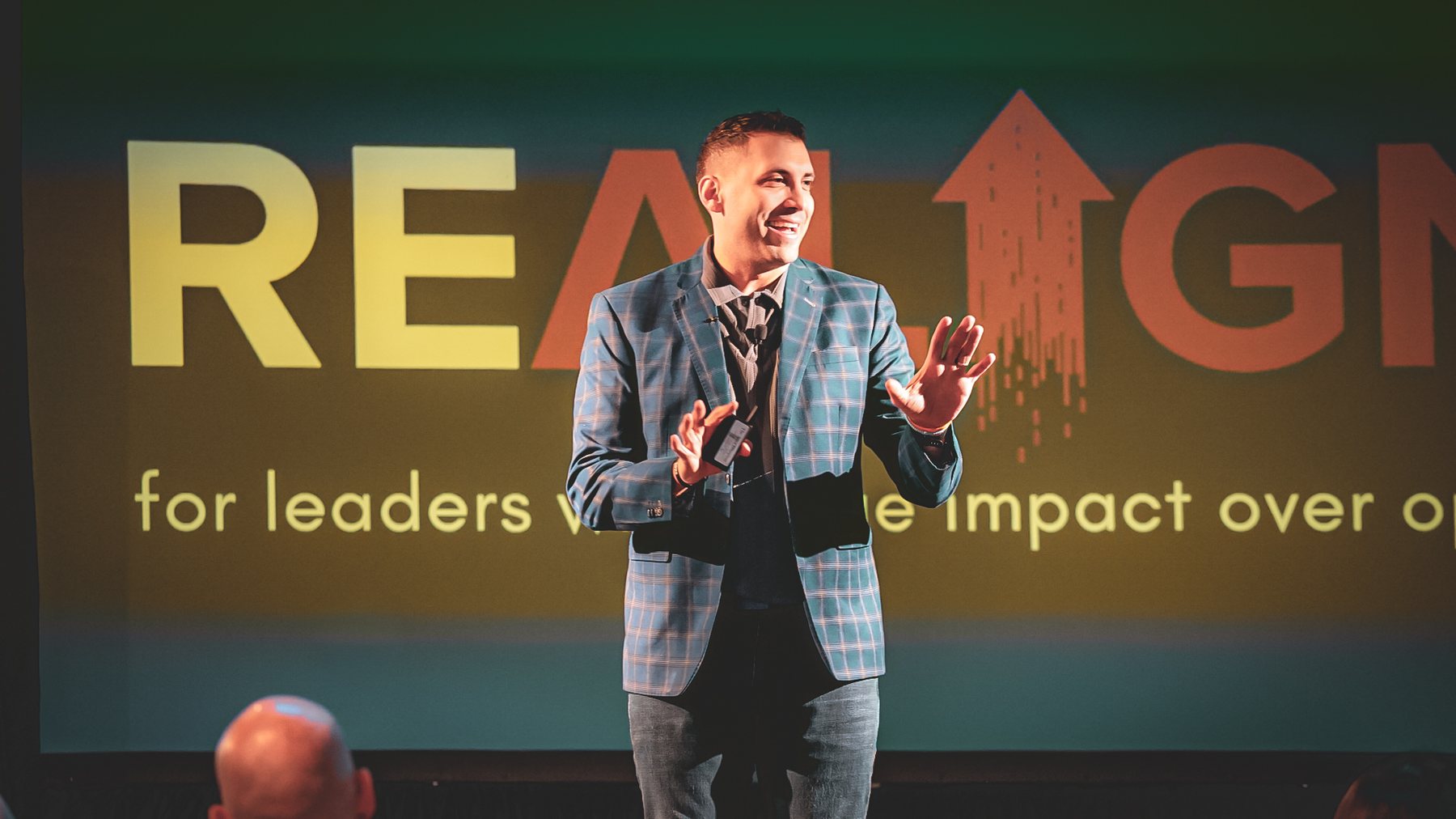 Matt Granados speaking on stage at a Life Pulse REALIGN event